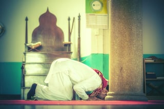 A Devout Muslim Man Engaged In Prayer Within The Mosque