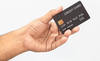 Black credit card held in hand