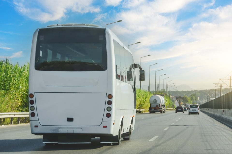 White Tourist Bus Driving On Highway